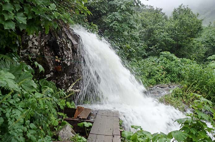 大雨の後で登山道に滝となって降り注ぐ沢水