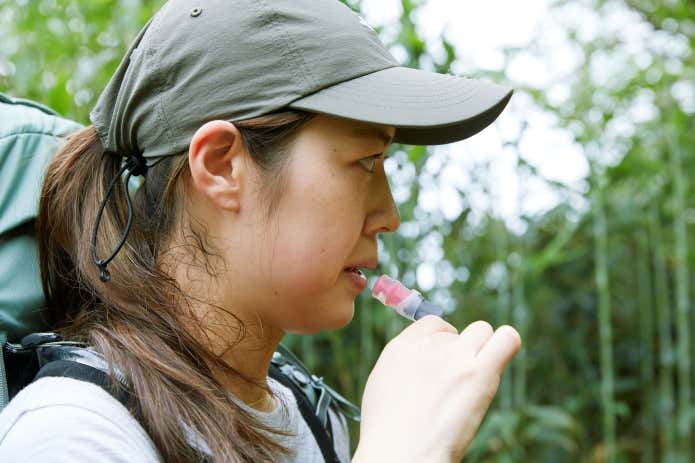 ハイドレーションで水分補給する登山者
