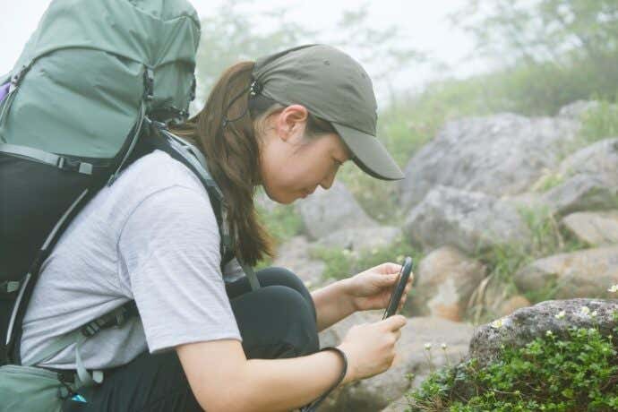高山植物を撮影する登山女性