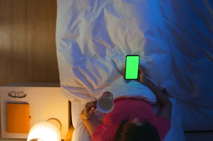 ベッドでスマートフォンを見る