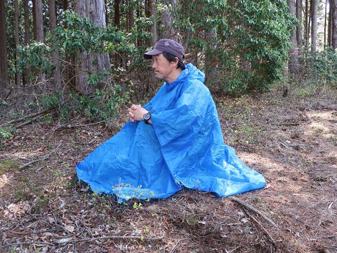 ポンチョを身にまといしゃがみこんだ状態