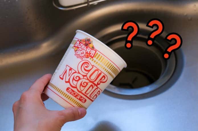 ラーメンのスープの残りを流しに流していいものか、悩んでいる様子