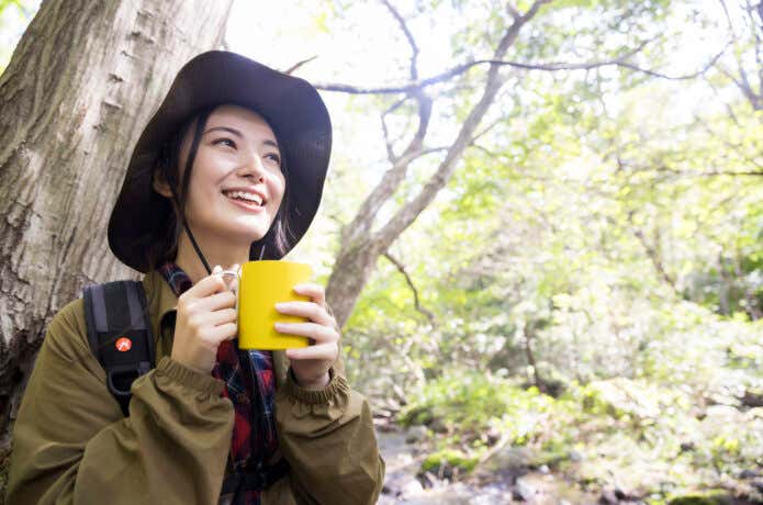 登山中にコーヒーを飲む女性