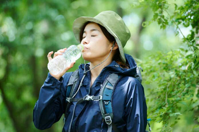 休憩中に水分補給＆アミノ酸サプリメントを摂る登山者