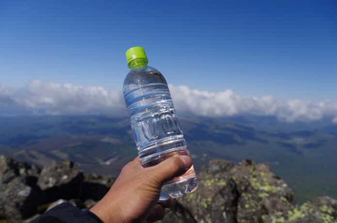 山でペットボトルを持っている画像