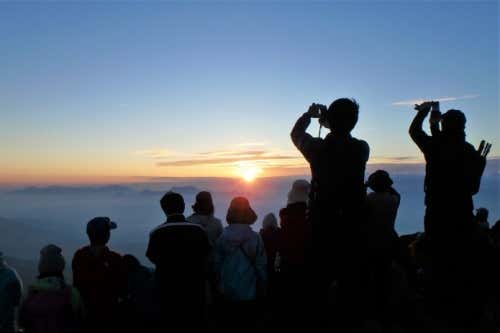 唐松岳の山頂にて、多くの登山者と一緒にご来光を望む