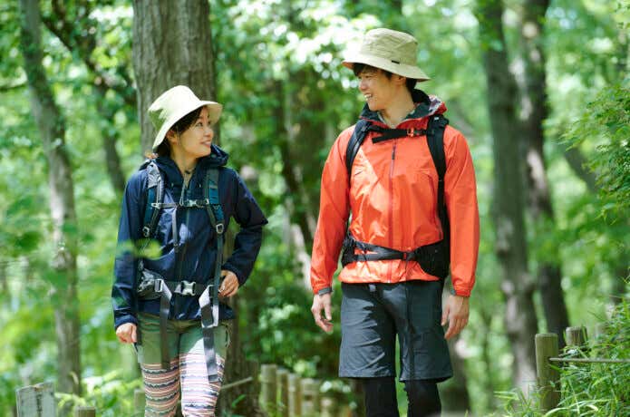 帽子をかぶって登山をする男女