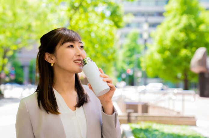水筒のコーヒーで休憩する会社員