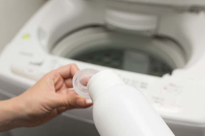 洗濯機に洗剤入れる様子