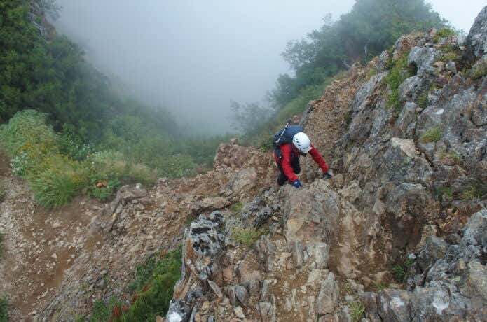 岩をしっかり掴んで登る登山者