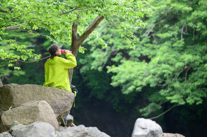 登山中に水分補給をする女性
