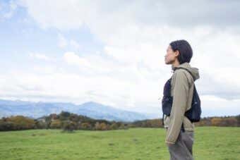 晴天の牧場に立つ女性