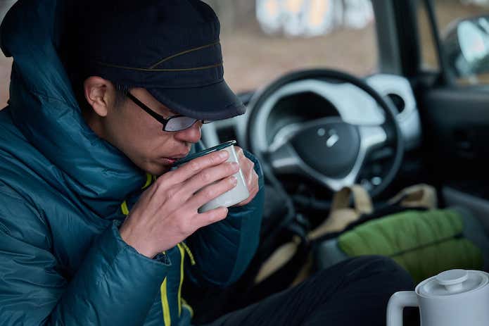 車内で味噌汁を飲む様子
