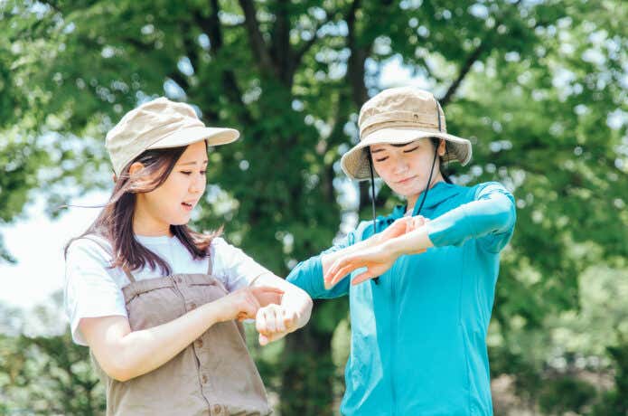 虫除けスプレーを塗る人