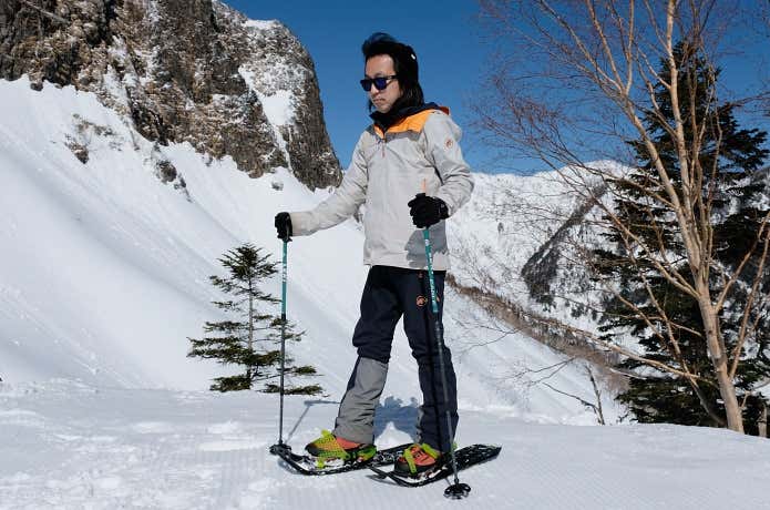 平坦な場所でスノーシューを装着した人