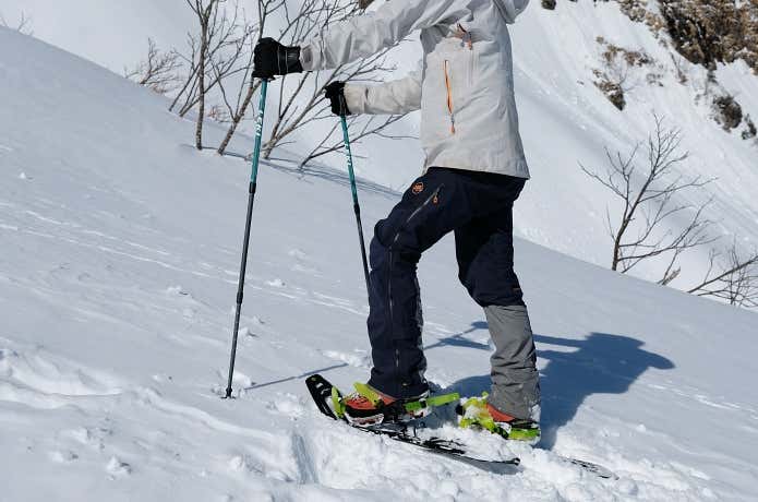 短めに調整したトレッキングポールを活用して斜面を登る人