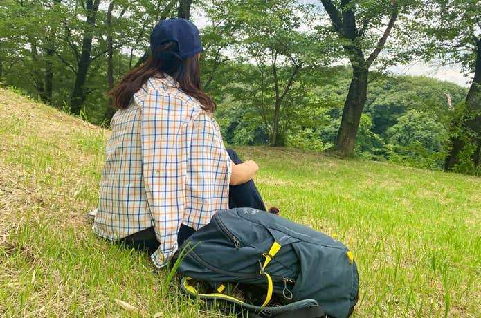 山頂でシャツを羽織る登山者