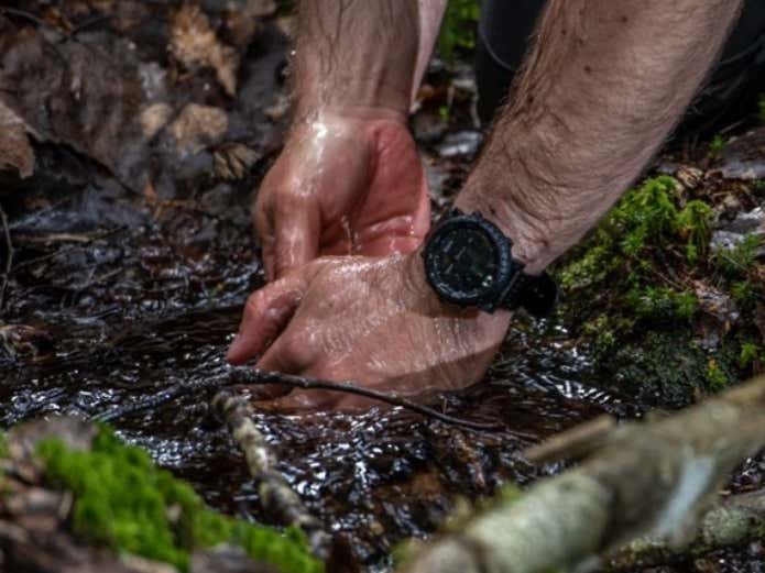 suunto coreをつけて川に手を入れる人