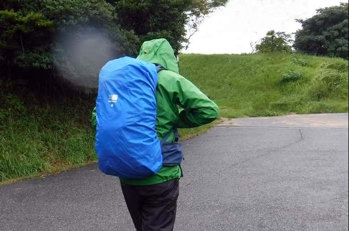 雨の中ザックカバーつけて歩く人