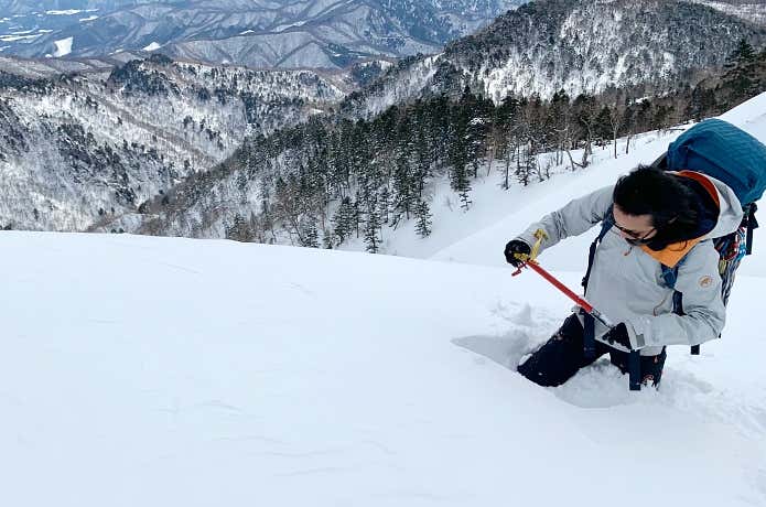 膝で雪を踏み固める