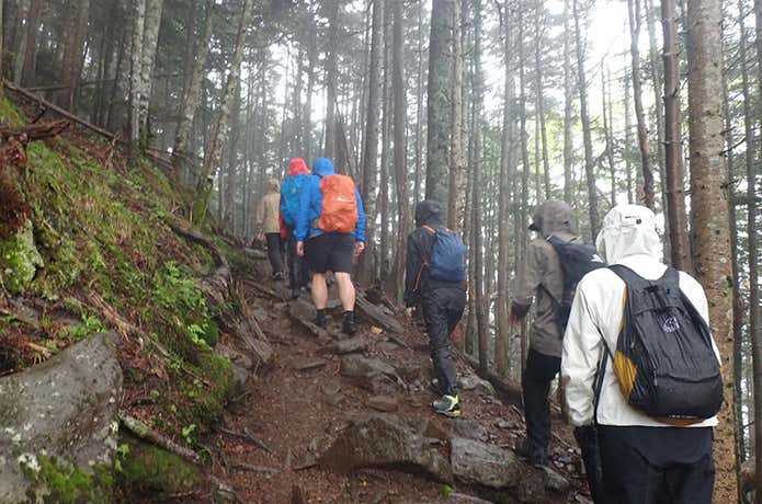 レインウェアを着て登山