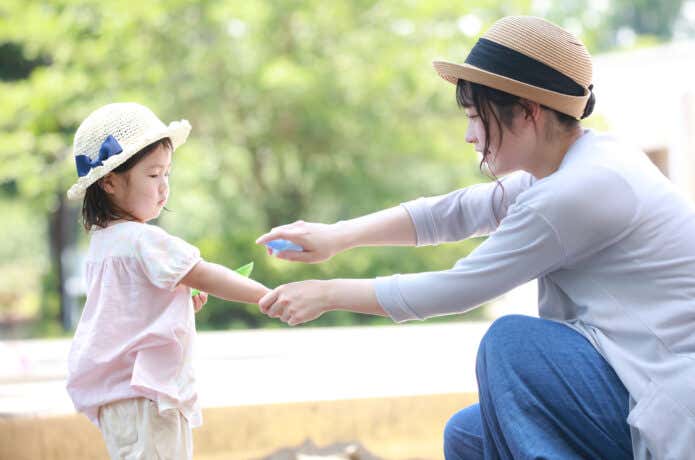 子どもに虫除けスプレーを吹きかける親