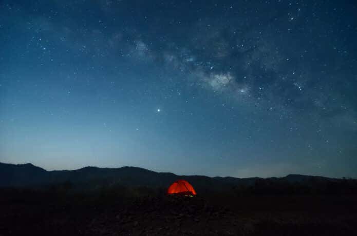 山の夜空と明るいテント