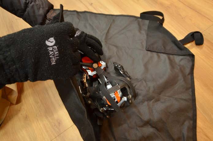 アイゼンをモンベルのクランポンラップに収納する様子