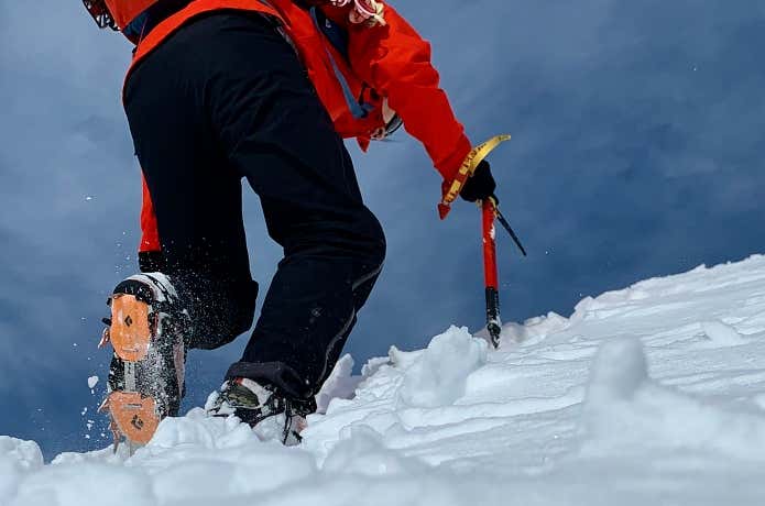 アイゼンを履いて雪山登山をする人