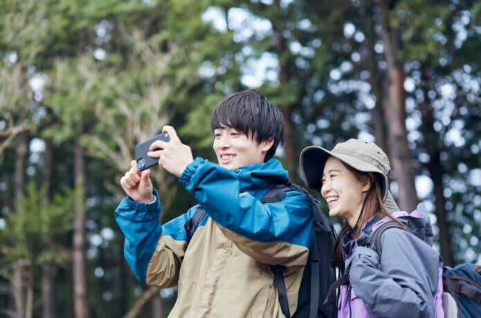登山でスマートフォンを取り出す人