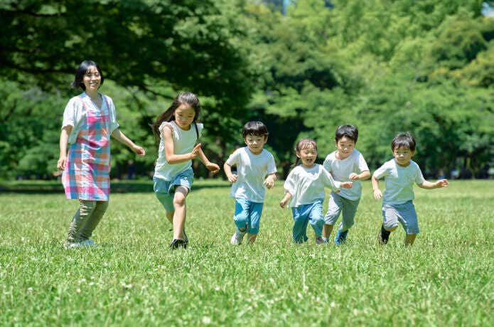 原っぱを駆け回る子どもたち