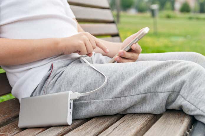 モバイルバッテリーからスマホを充電する人