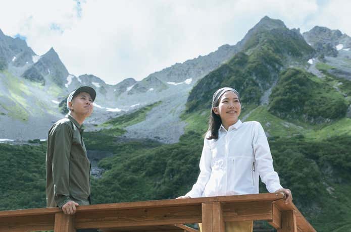 山を背景にベンチレーションシャツを着用した男女