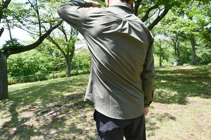 ストレッチ素材のシャツを着て腕を上げる男性