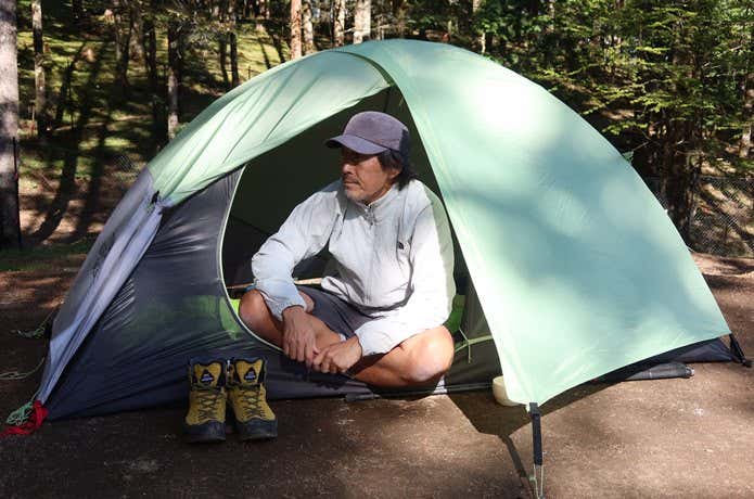 山岳テントの中に座る男性