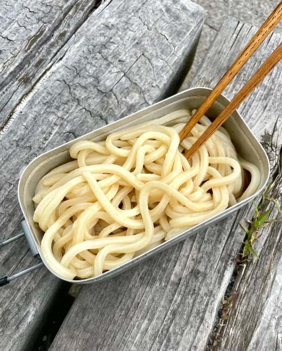 ③うどんを入れたメスティンに、めんつゆ、水、ポン酢を入れてまぜる。