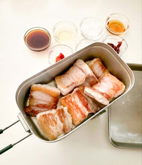 ②メスティンを熱し、サラダ油適量（分量外）とにんにくを引き、豚バラを焼く。