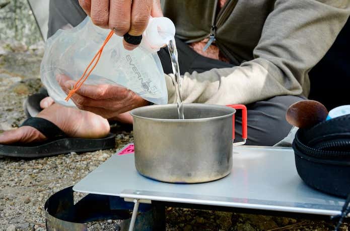 エバニューのチタン製クッカーを使用する登山者