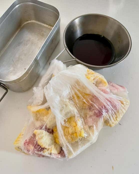 ③メスティンにサラダ油(大さじ1/分量外)を入れて火にかけ、にんにく、豚肉、とうもろこしを入れて炒める。