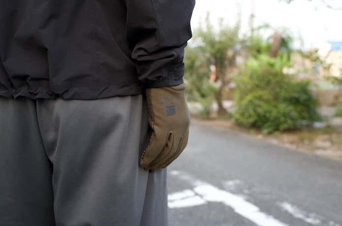 グローブをはめて街を歩く男性