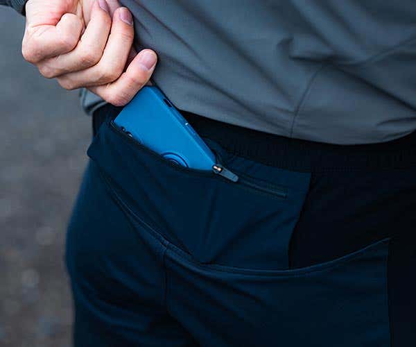 スカイトレイルパンツの背面ポケットにスマホを入れている様子