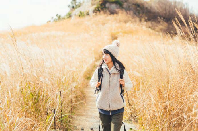 ベストを着て山を歩く女性