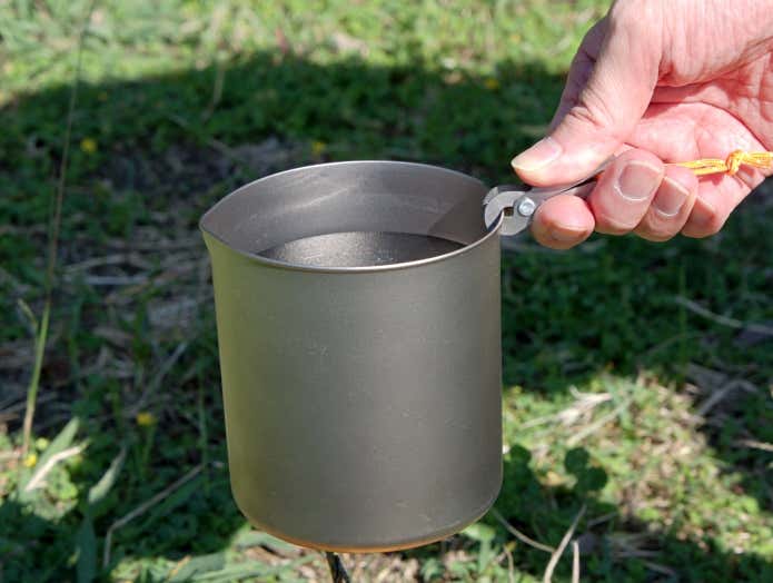 500mlの水が入ったクッカーをEPIgasのピンチリフターで持ち上げる様子