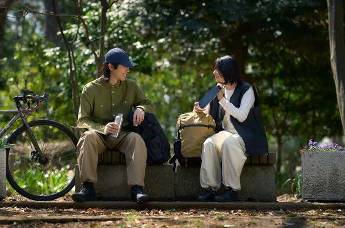 ホグロフスのリュックをはさんで談笑する男女