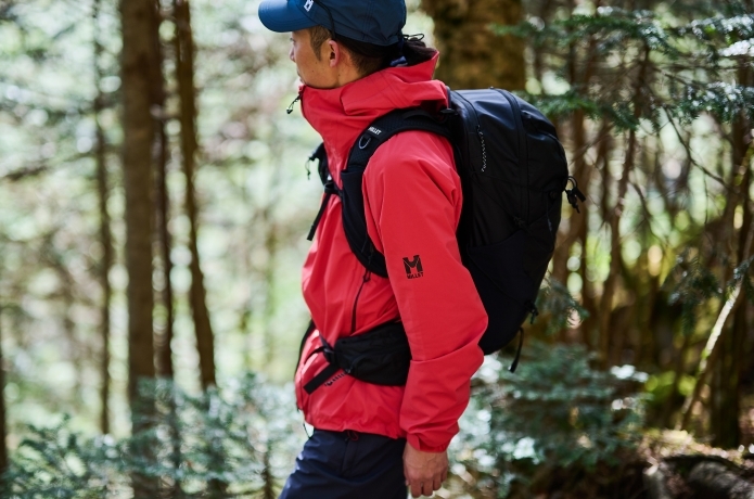レインウェアを着て山を歩く人の横カット