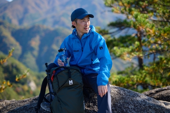 ミレーのレインウェアを着て休憩する人