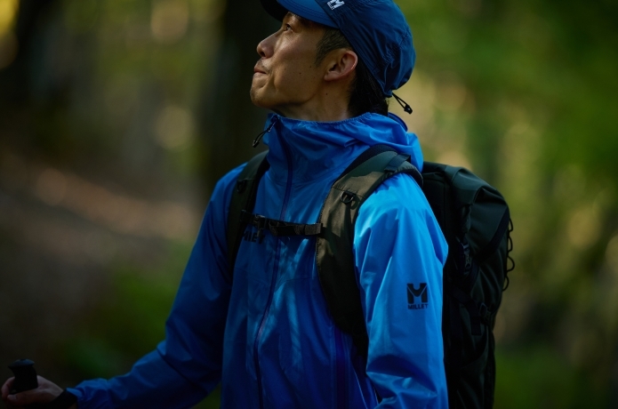 ミレーのレインウェアを着用して見上げる人