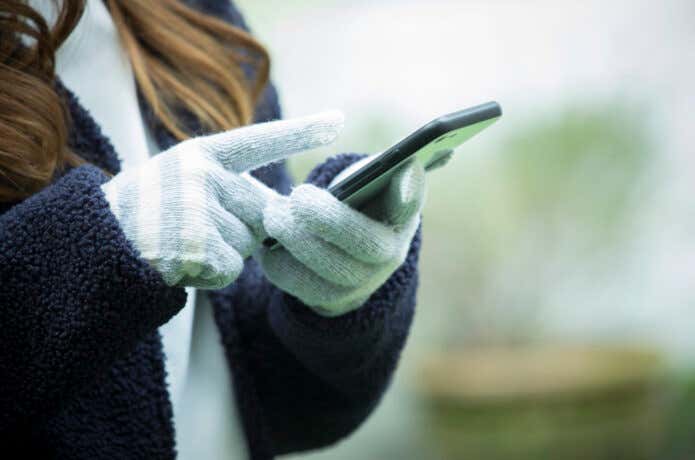 スマホ対応手袋でスマホを操作する女性