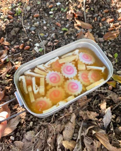 ①なると、油揚げを食べやすい大きさに切る。②メスティンにお米、白だし、しょうゆ、酒を入れてから、リベット(メスティン内側にある丸ぽち)の真ん中に水を合わせる。その後に、なると、油揚げを入れる。