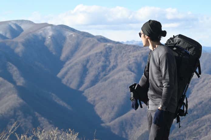 ファイントラックのベースレイヤーを着る登山者と秩父の山